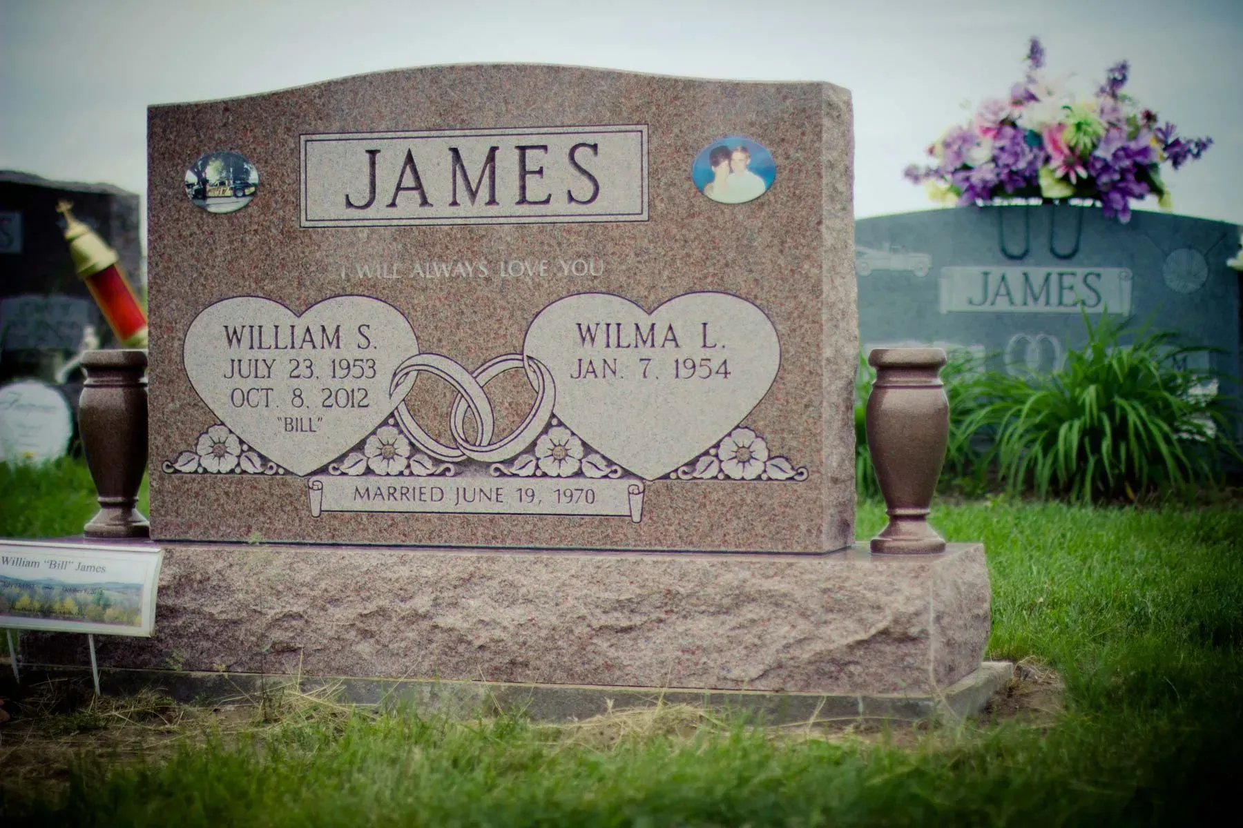 James family gravestone with floral etchings in a cemetery, with another James monument in the background