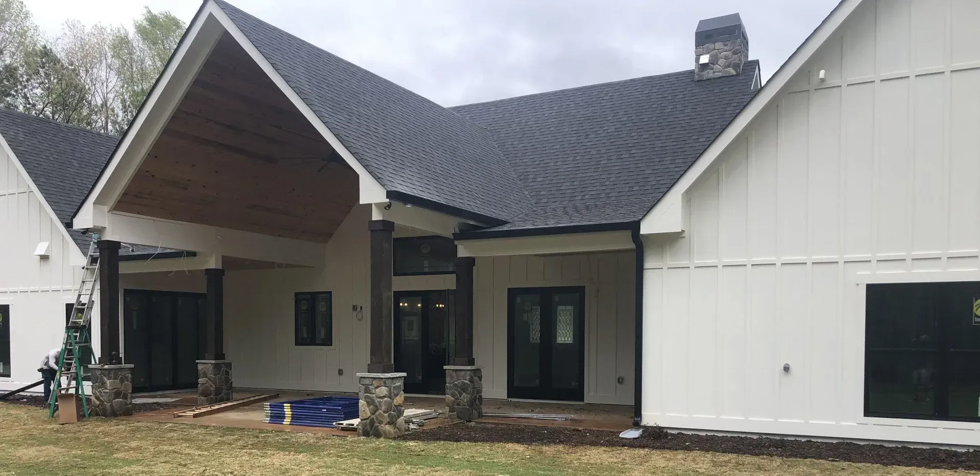 White modern farmhouse style house with dark roof and trim.