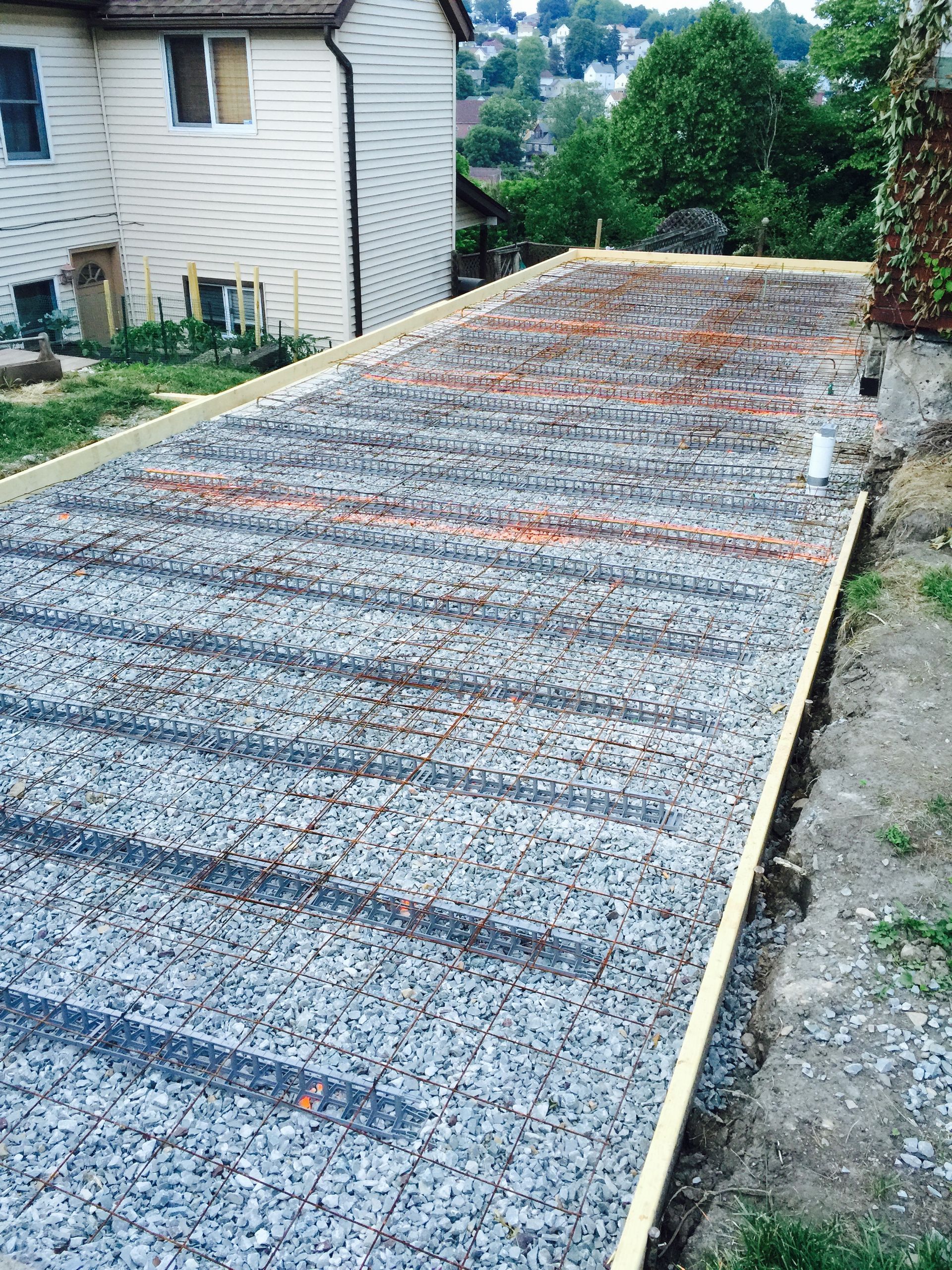 A gravel-filled rectangular formwork, ready for concrete pouring, prepared outdoors.