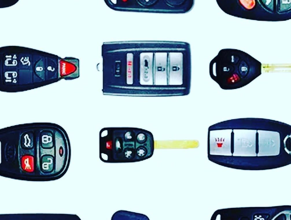 Assortment of car key fobs and remote controls on a white background