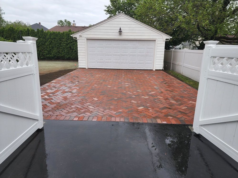 A garage with a brick driveway 