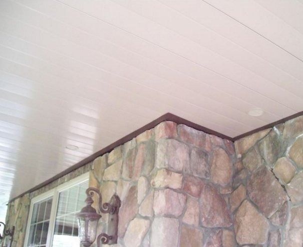 White ceiling with brown trim above a stone wall, possibly an outdoor porch.