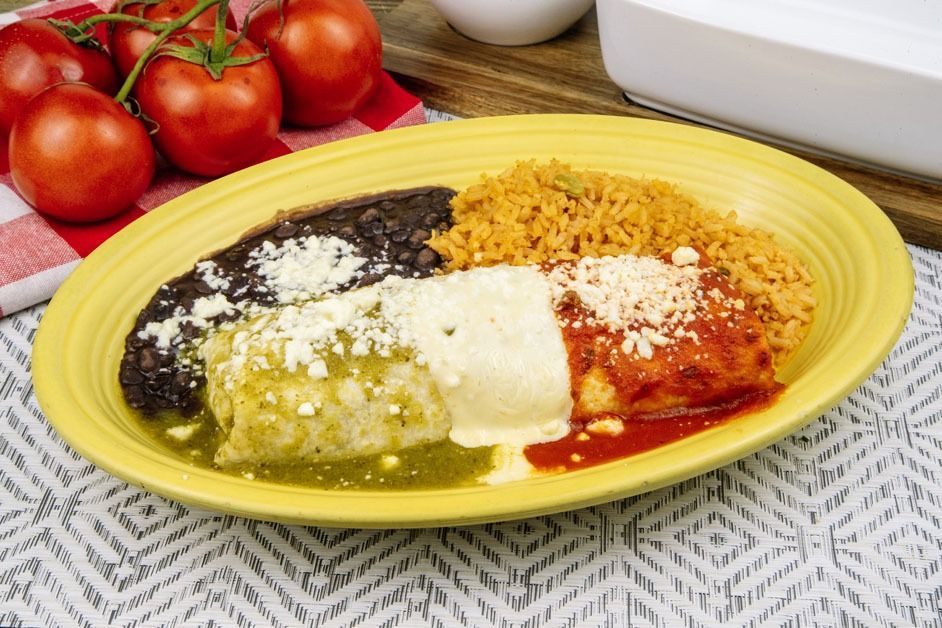 A plate of food with rice , beans and cheese on a table.