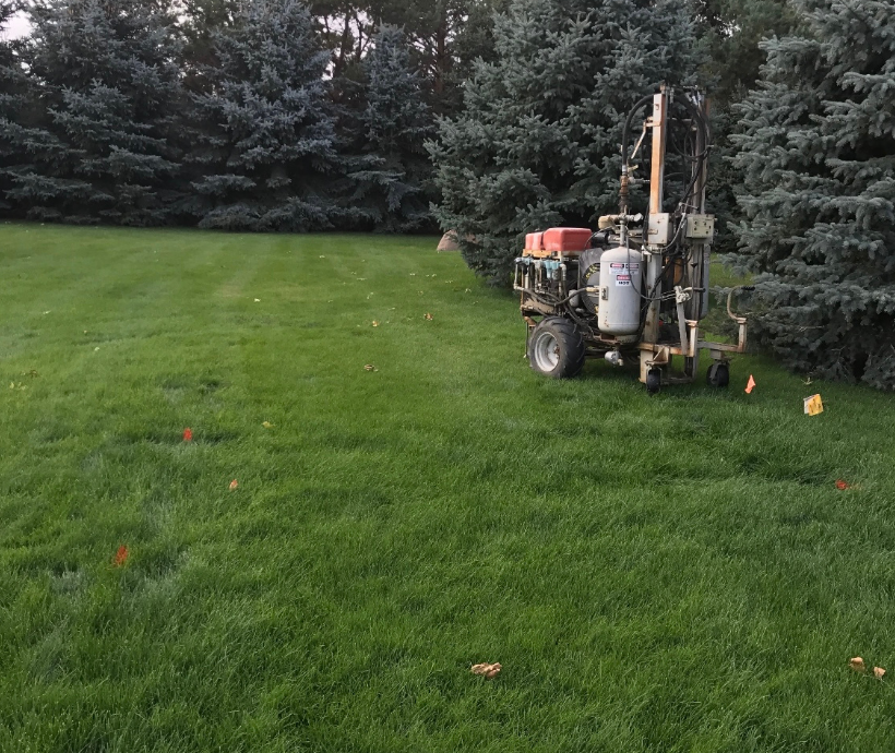 A lawn mower is parked in the middle of a lush green field.