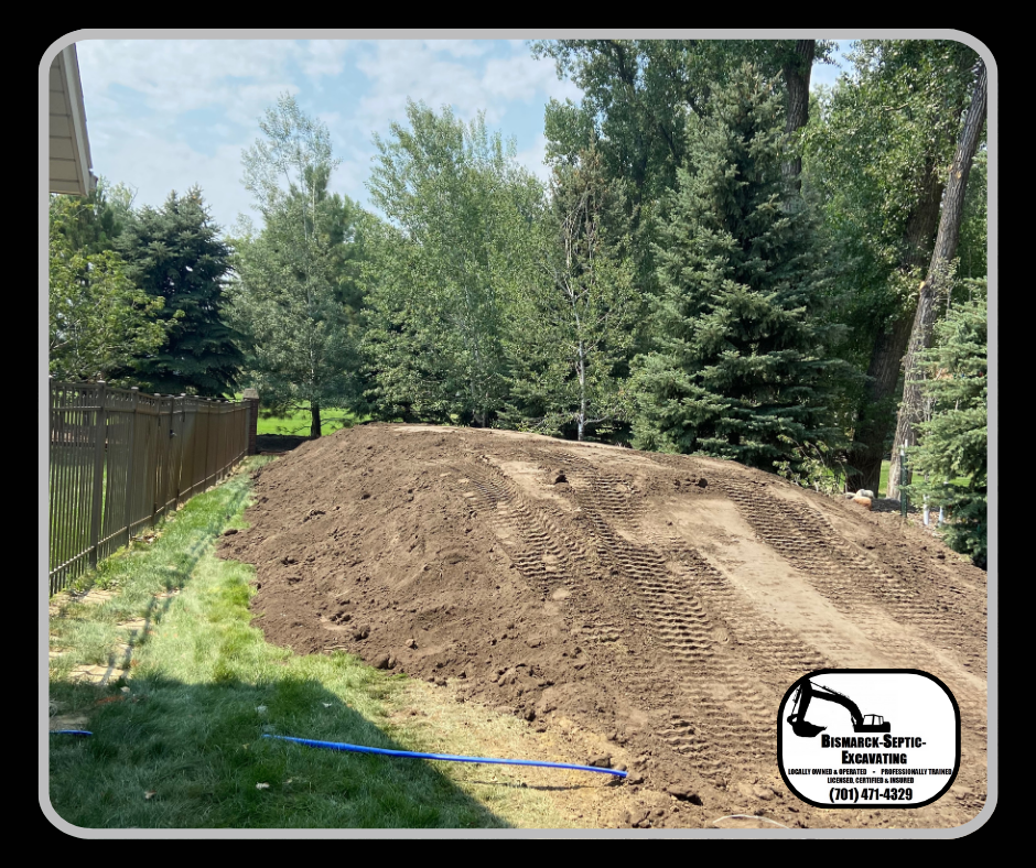 There is a large pile of dirt in the middle of a yard.