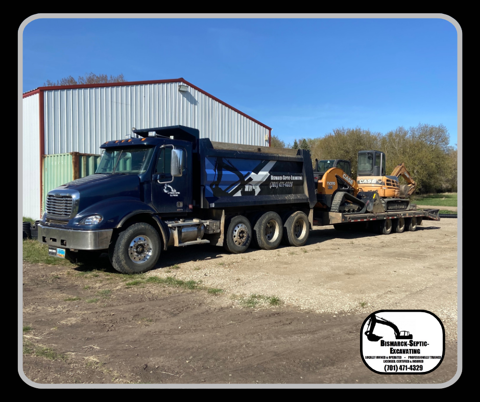 A dump truck with an excavator on the back is parked in front of a building.