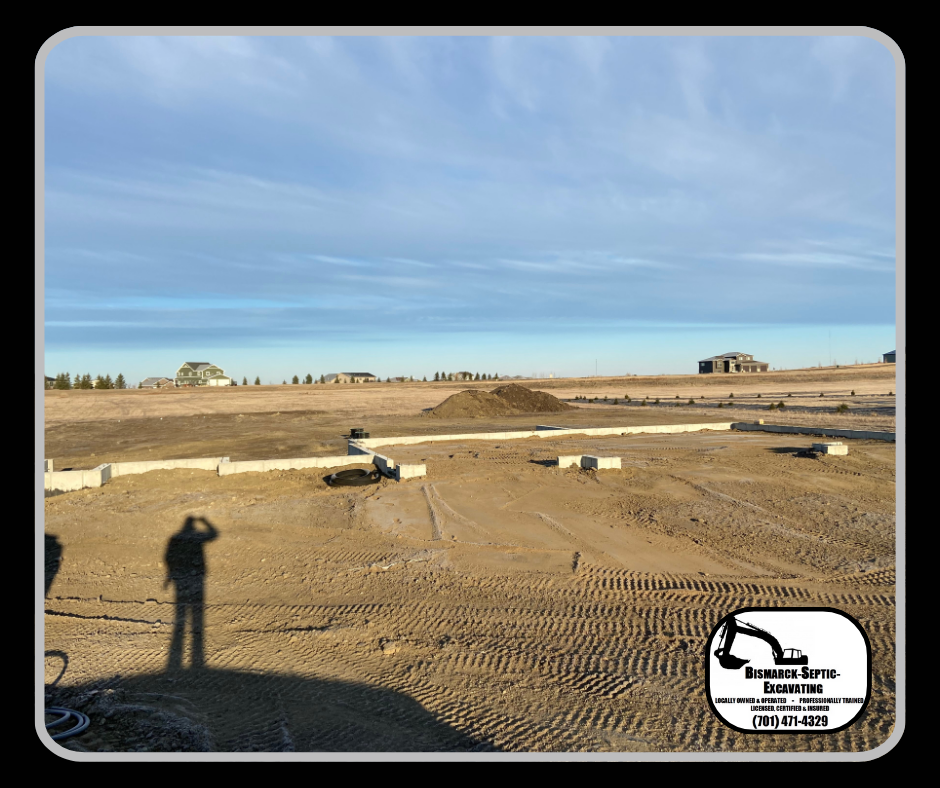 A man is standing in the middle of a dirt field.