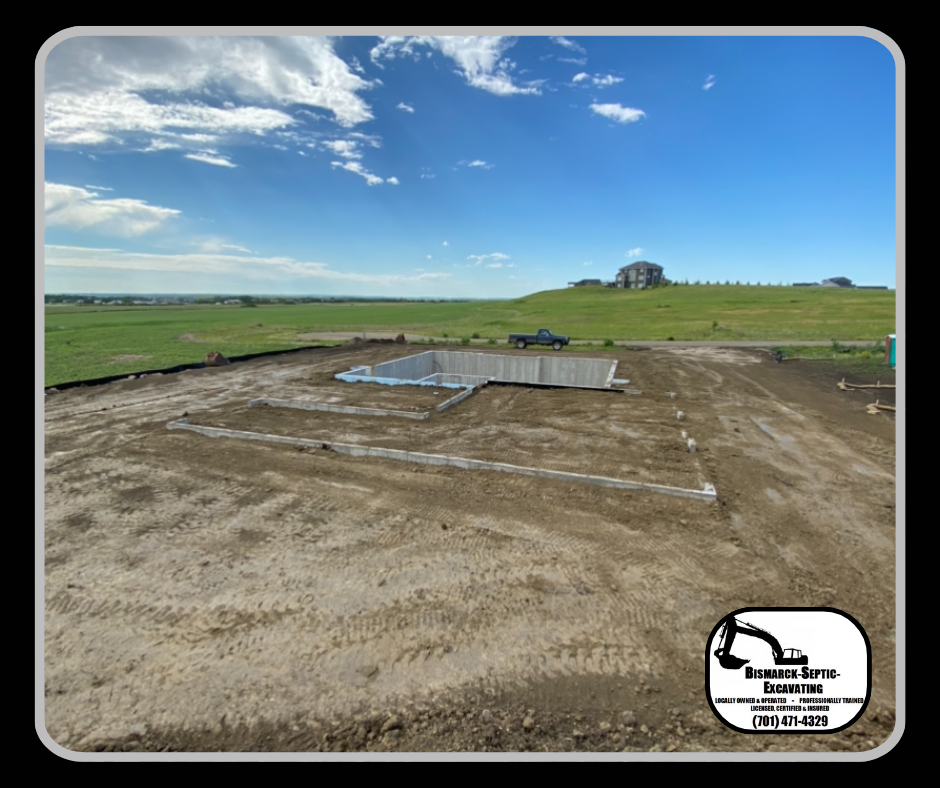 A large dirt field with a concrete foundation in the middle of it.