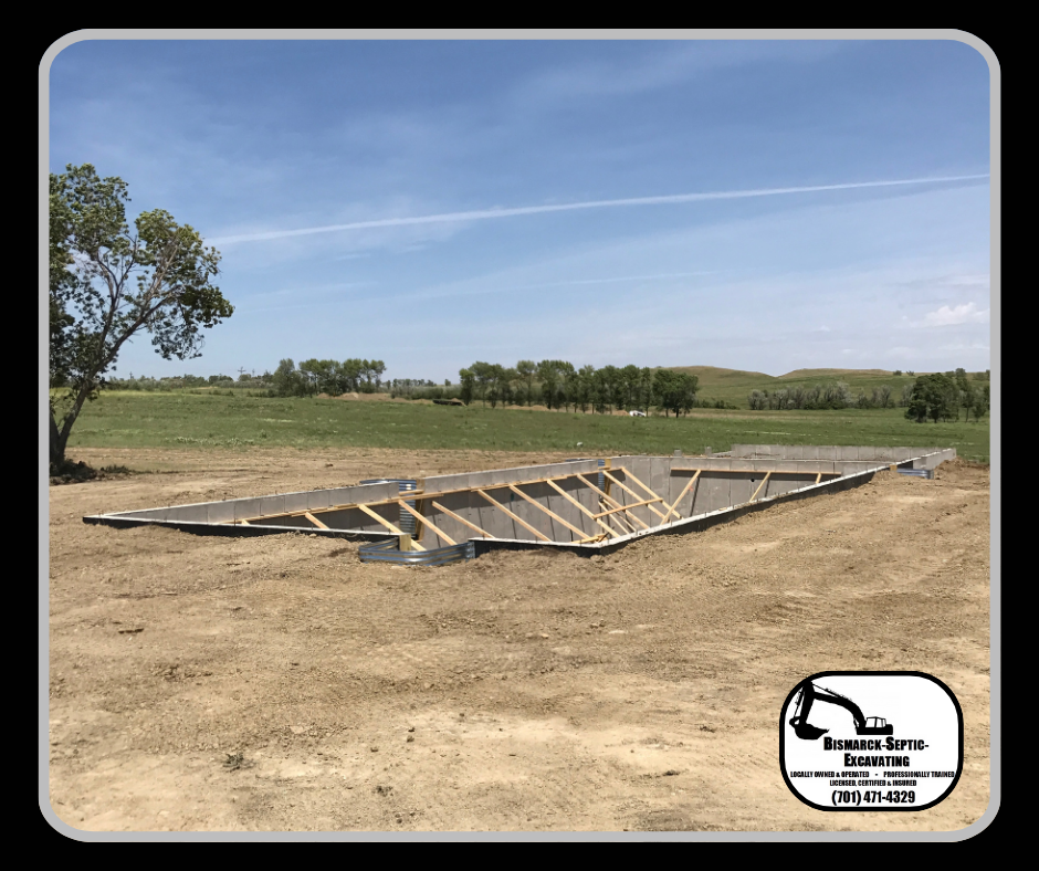 A large wooden structure is sitting in the middle of a dirt field.