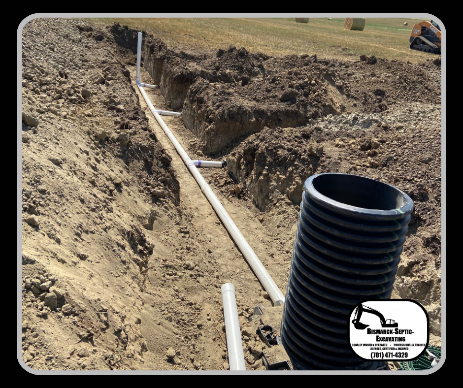 A black pipe is laying in the dirt next to a white pipe.