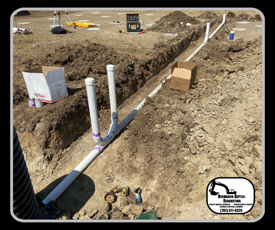 A person is standing in the dirt next to a row of pipes.