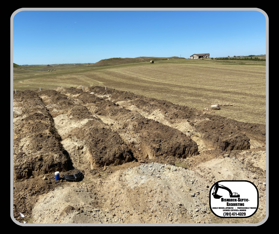 A large dirt field with a house in the background.