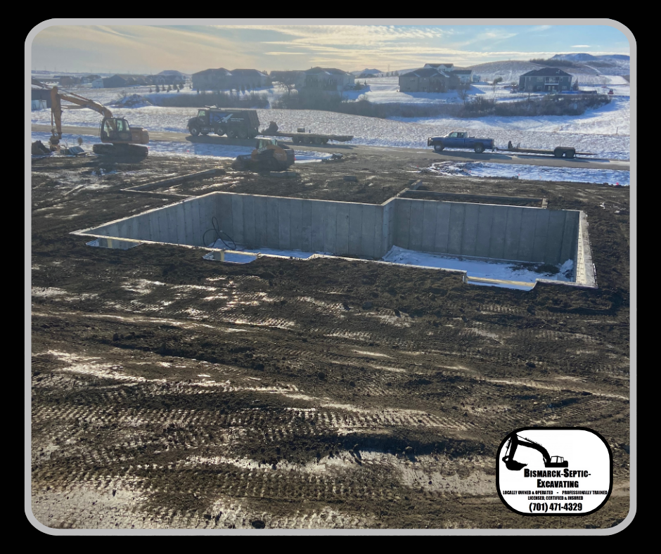 A large concrete foundation is being built in a dirt field.