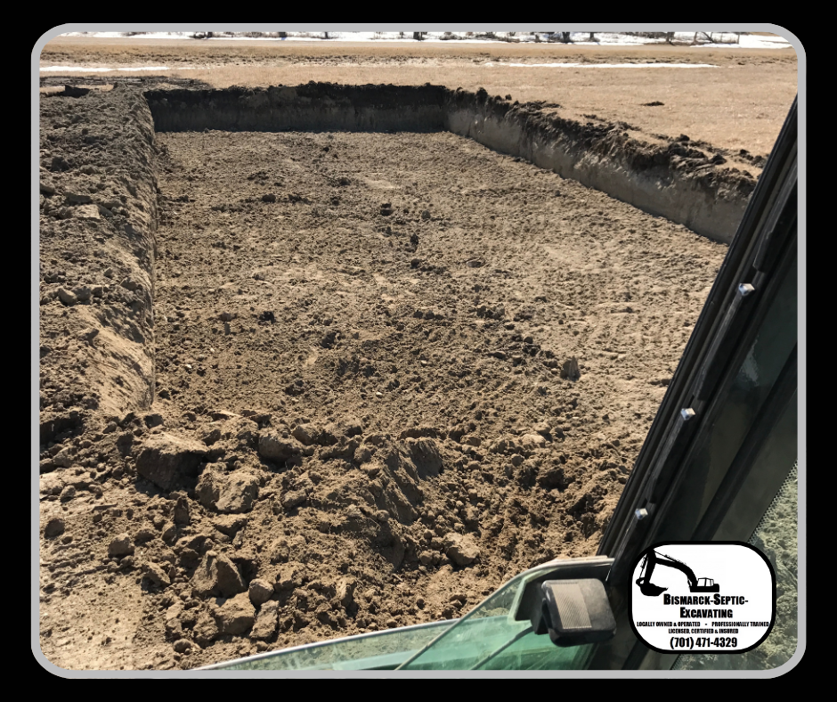 A tractor is digging a hole in the dirt in a field.