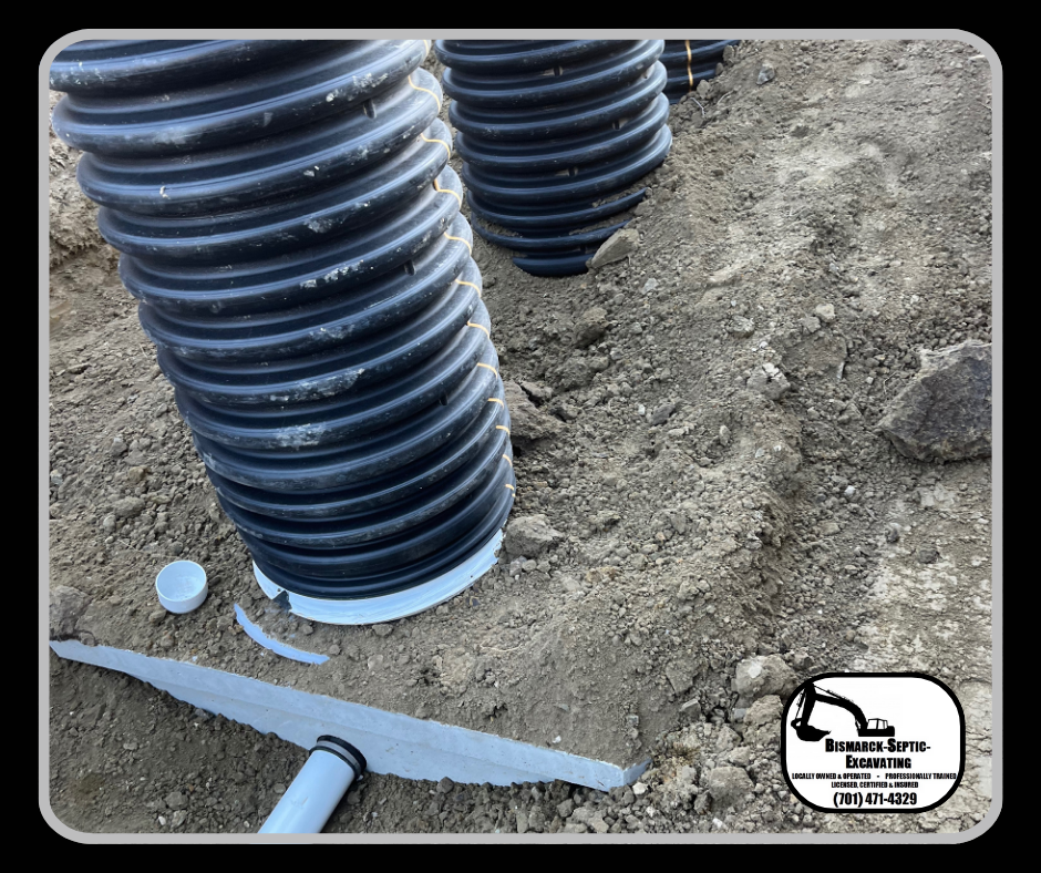 A stack of black pipes sitting on top of a pile of dirt.