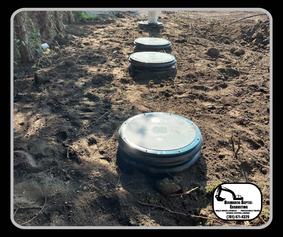 A row of septic tanks sitting on top of a dirt field.