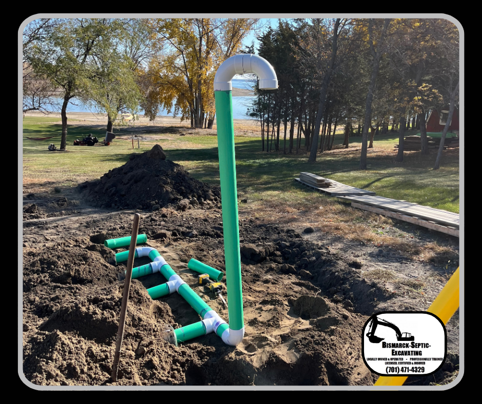 A green pipe is sitting in the dirt next to a pile of dirt.