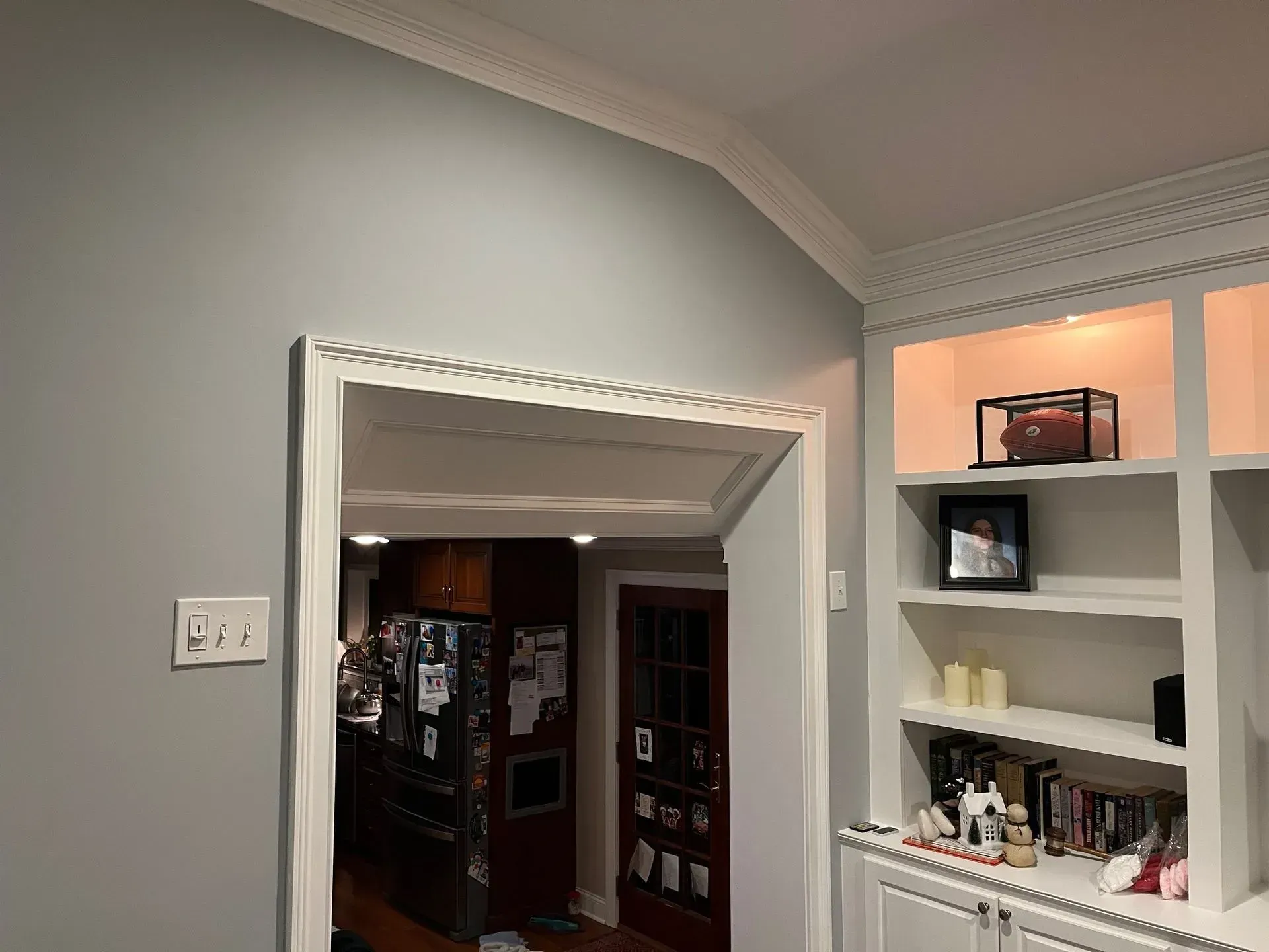 Interior room with gray walls, white trim, and built-in shelves holding decor and books.