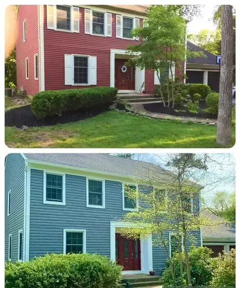 Two suburban houses with two-story facades, one red and one blue, each with a front lawn and shrubs