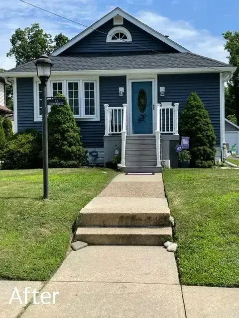 Front walkway with concrete steps leading to a blue house with white trim and a small porch.