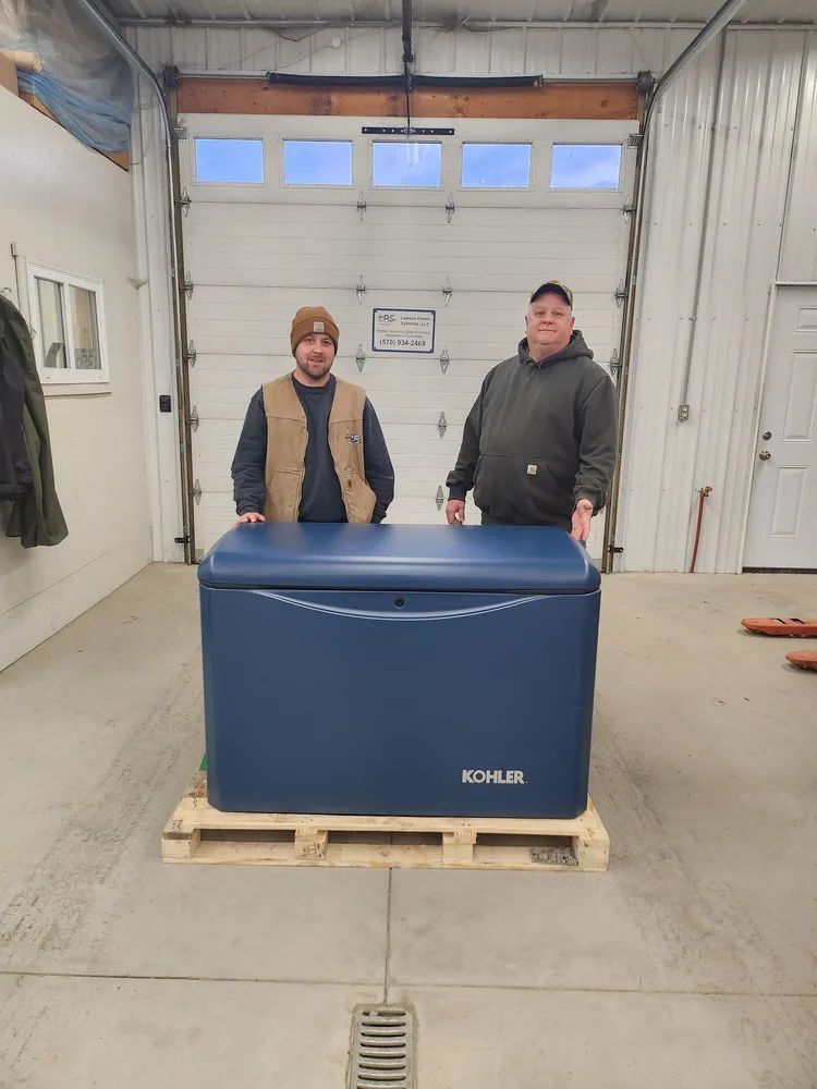 Two people stand behind a large blue chest on a pallet in a warehouse garage.