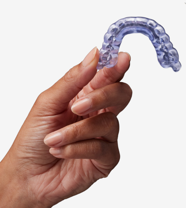 A person is holding a purple mouth guard in their hand.