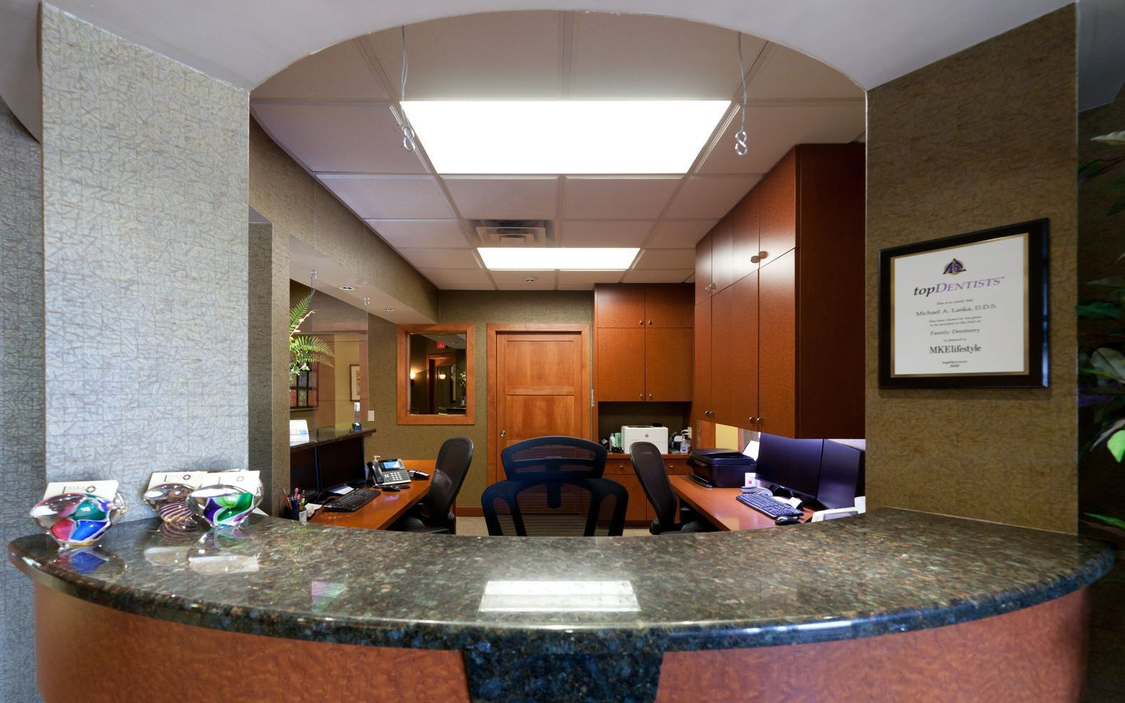 A dental office with a round counter and a picture on the wall