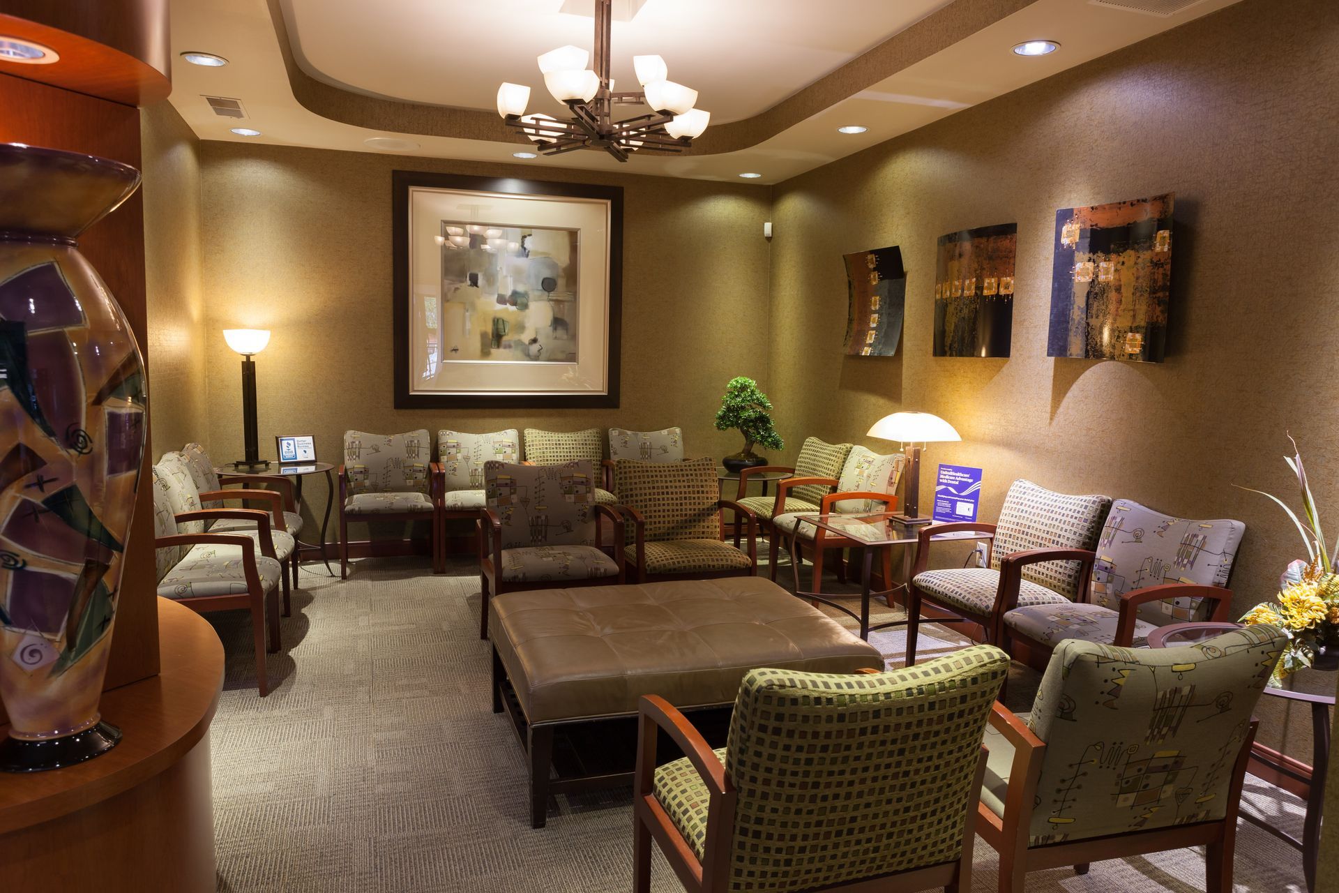 A waiting room with chairs, tables, and a chandelier.
