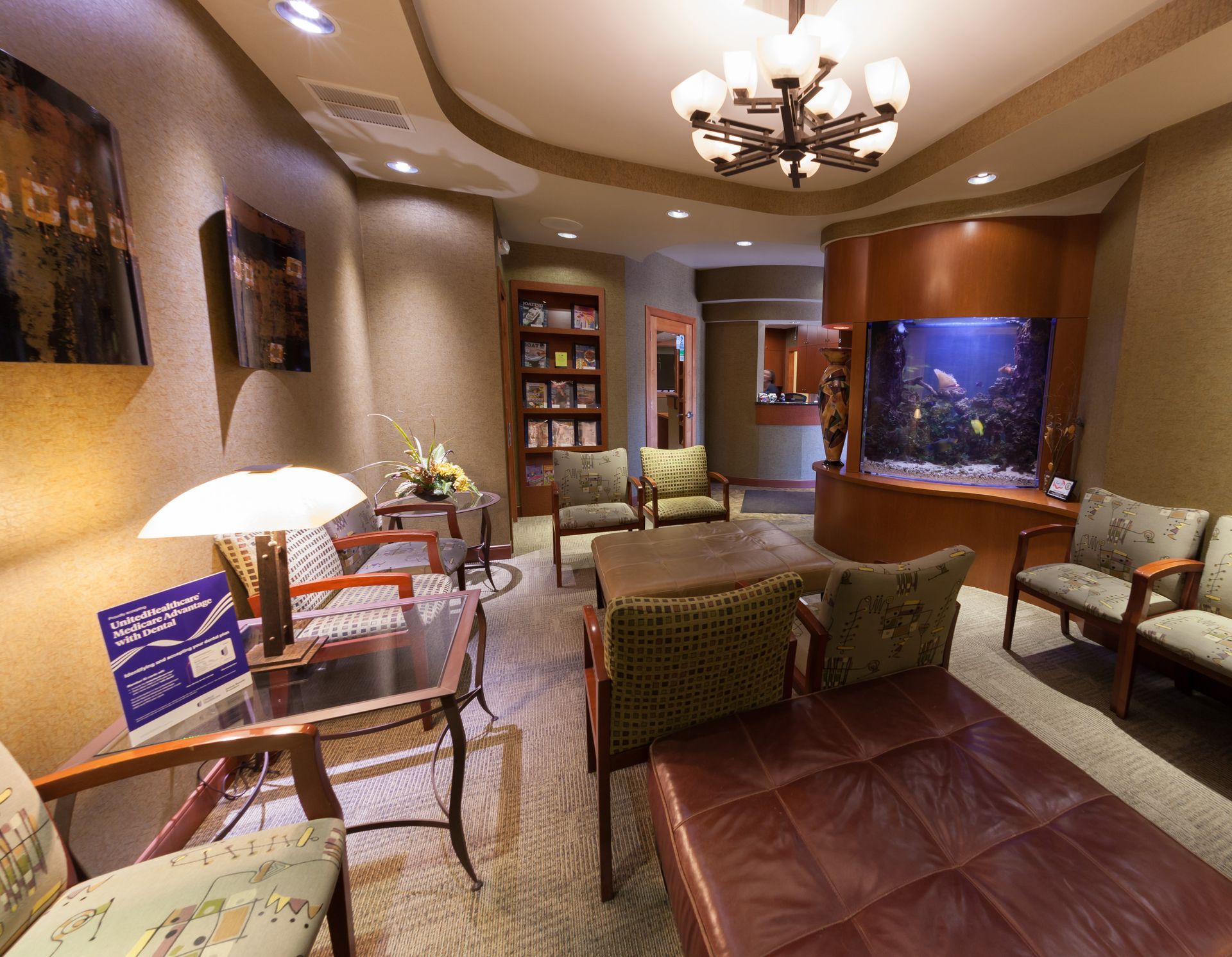 A waiting room with chairs, a table, and an aquarium.
