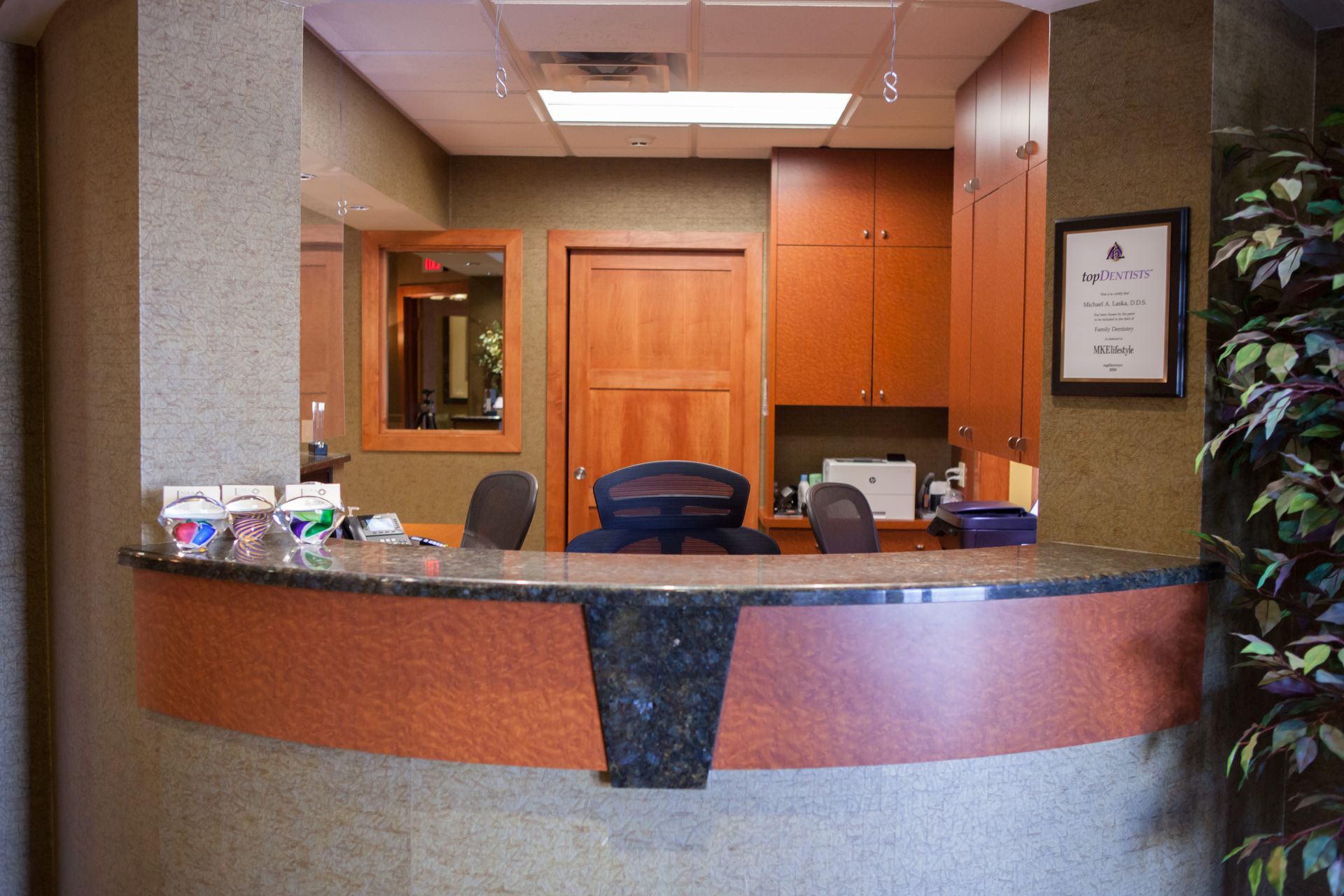 A reception desk in a dental office with a picture on the wall above it.