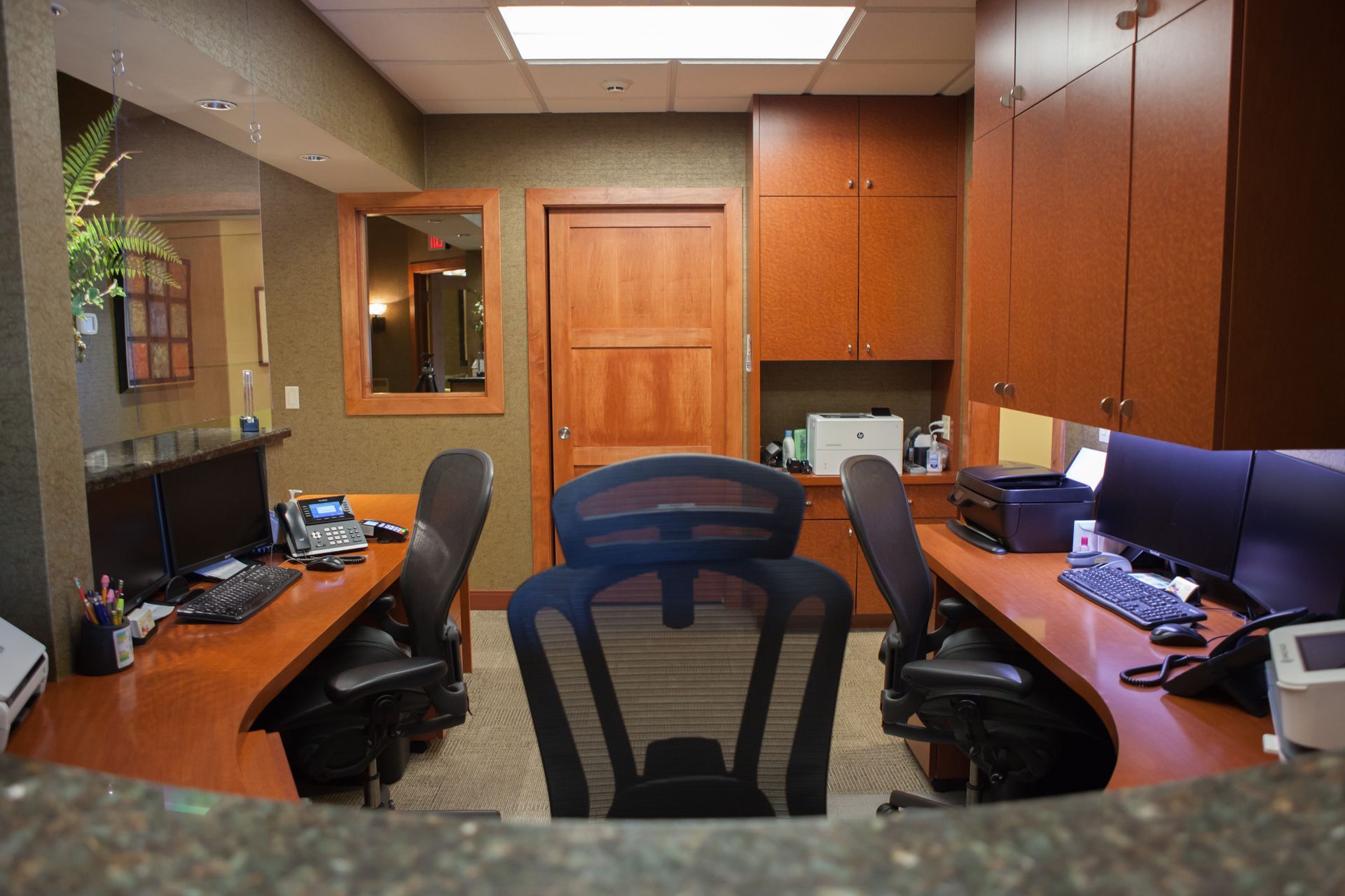 A dental office with two desks and two chairs.