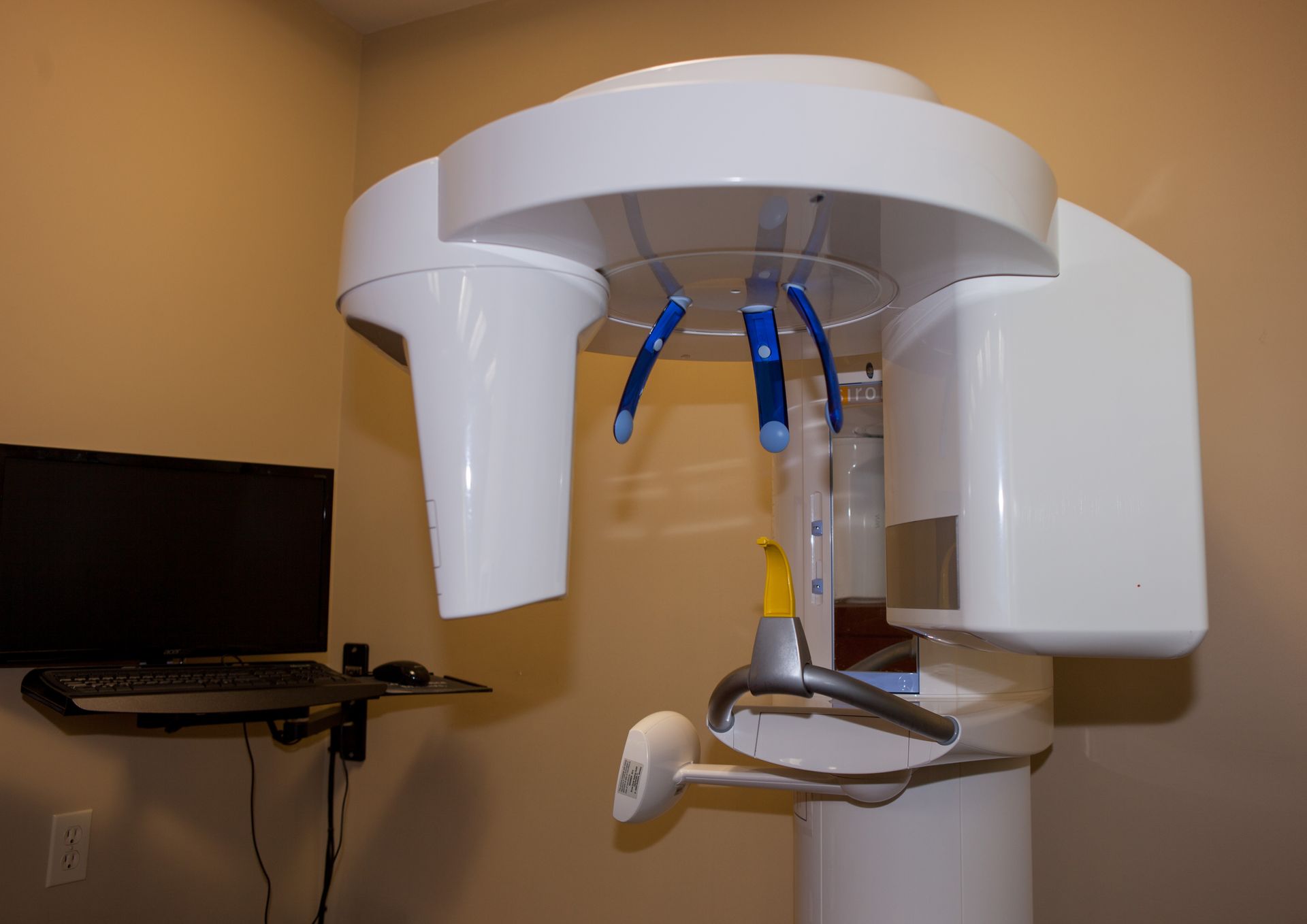 An x-ray machine is sitting in a room next to a computer.
