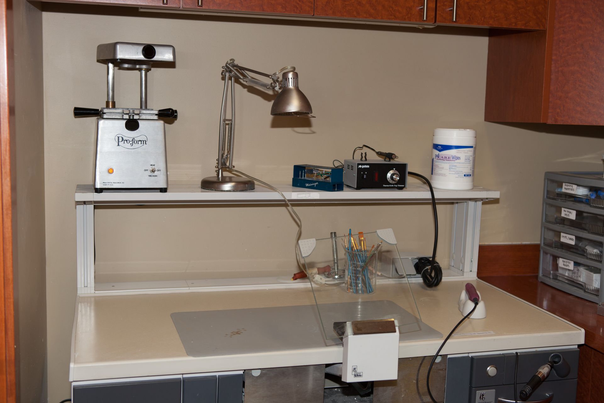 A desk with a lamp and a machine on it.