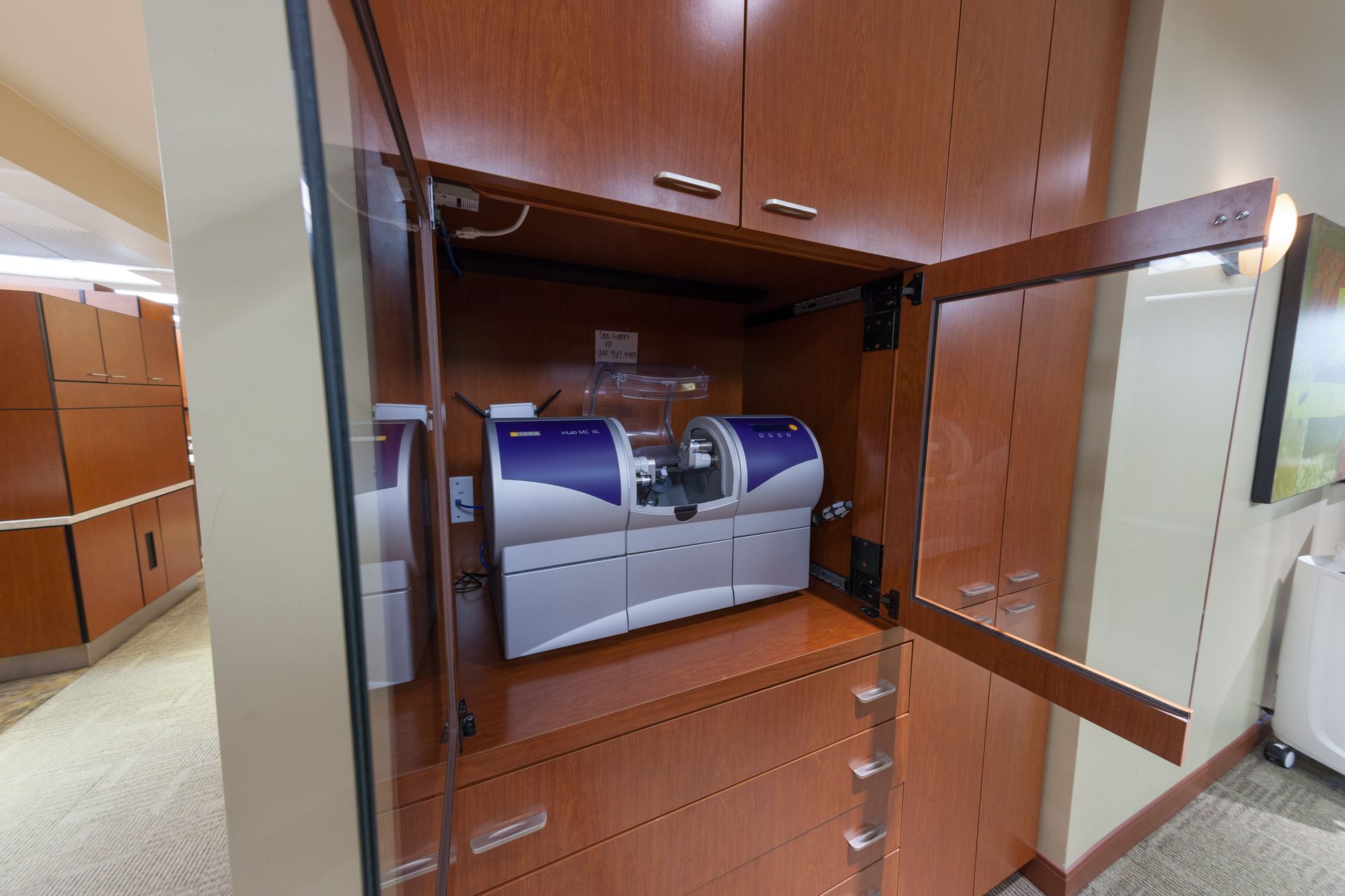 A machine is sitting inside of a cabinet with the door open.