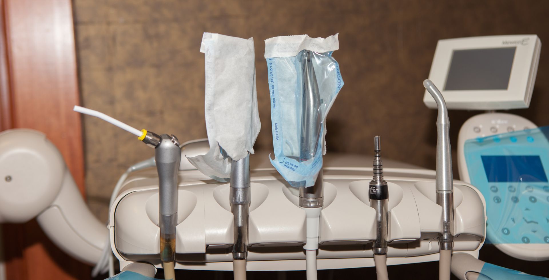 A dental chair with a bunch of dental instruments on it.