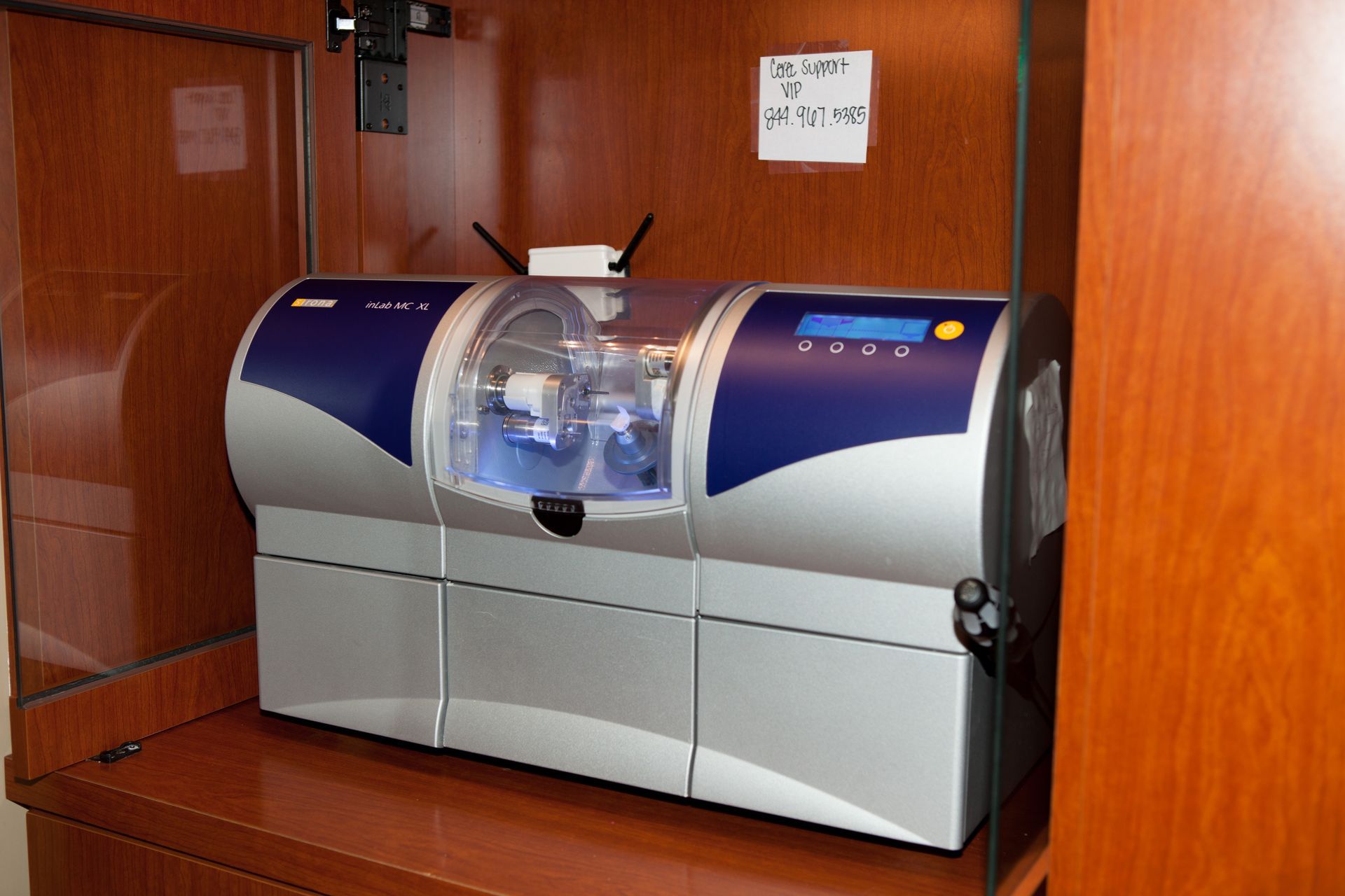 A dental machine is sitting on a wooden shelf.