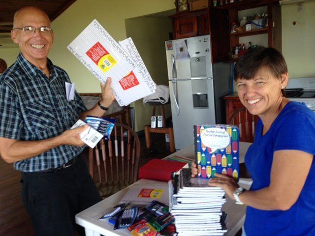 A man and a woman standing next to each other holding books