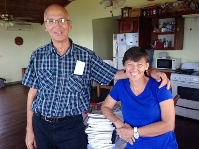 A man and a woman are posing for a picture in a kitchen