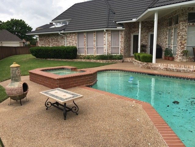 Backyard with pool, hot tub, patio, brick house.