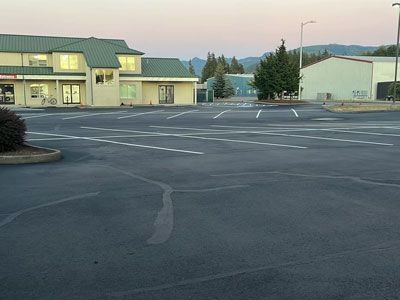 An empty parking lot with a building in the background.