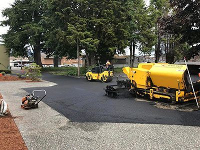 A couple of yellow trucks are driving down a road.