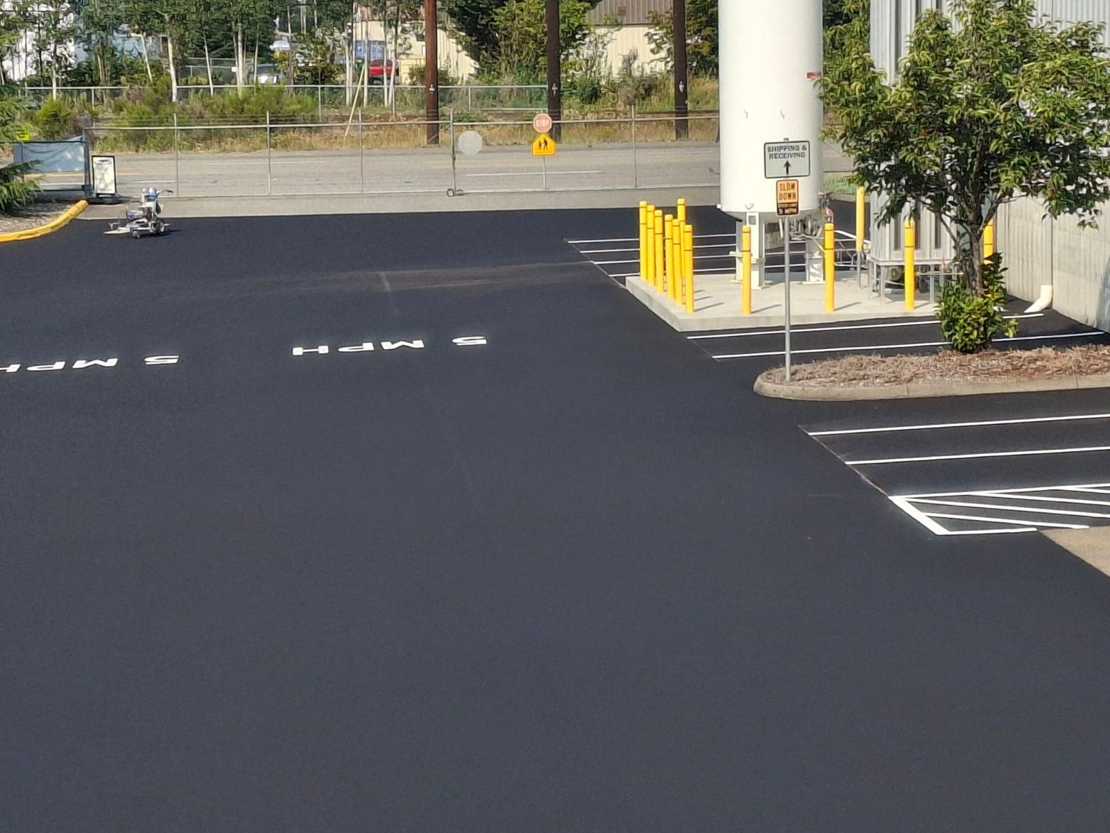 A parking lot with a white tank in the background