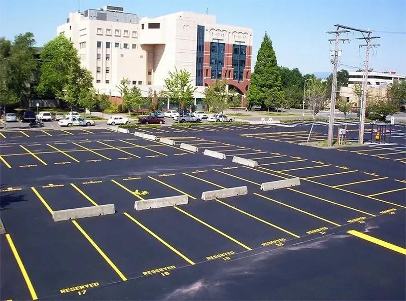 Newly paved parking lot with spaces designated as reserved