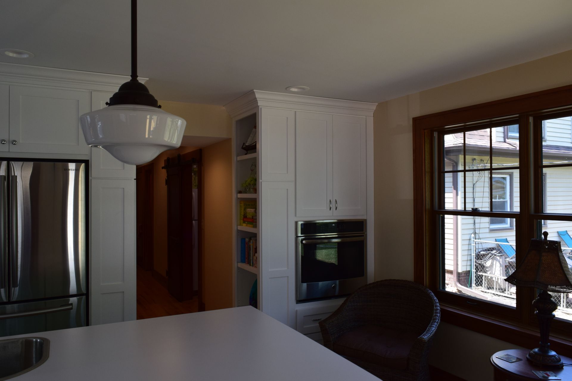 A kitchen with white cabinets and a stainless steel refrigerator