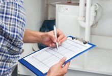 Plumber using checklist for annual certification