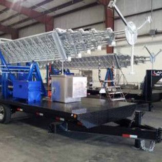 A large ladder is on a trailer in a warehouse.