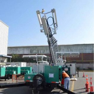 A man is standing next to a crane in a parking lot.