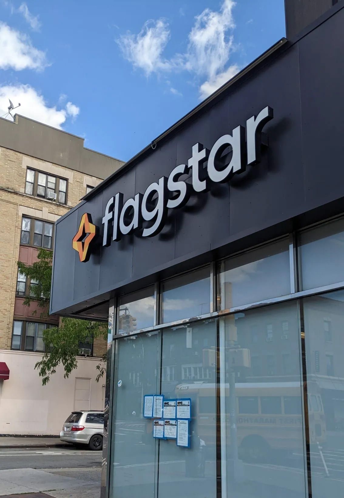 A flagstar store is located on the corner of a city street
