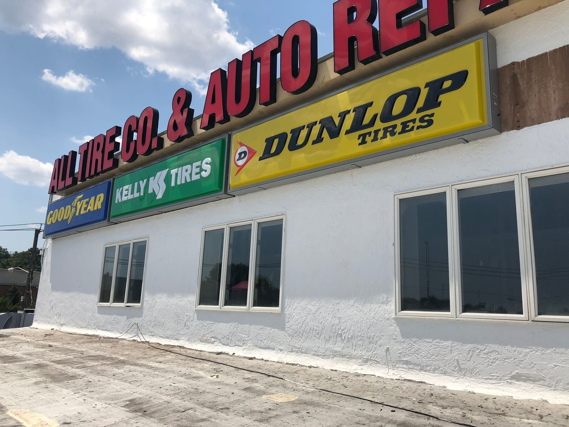 A white building with a yellow sign that says dunlop tires
