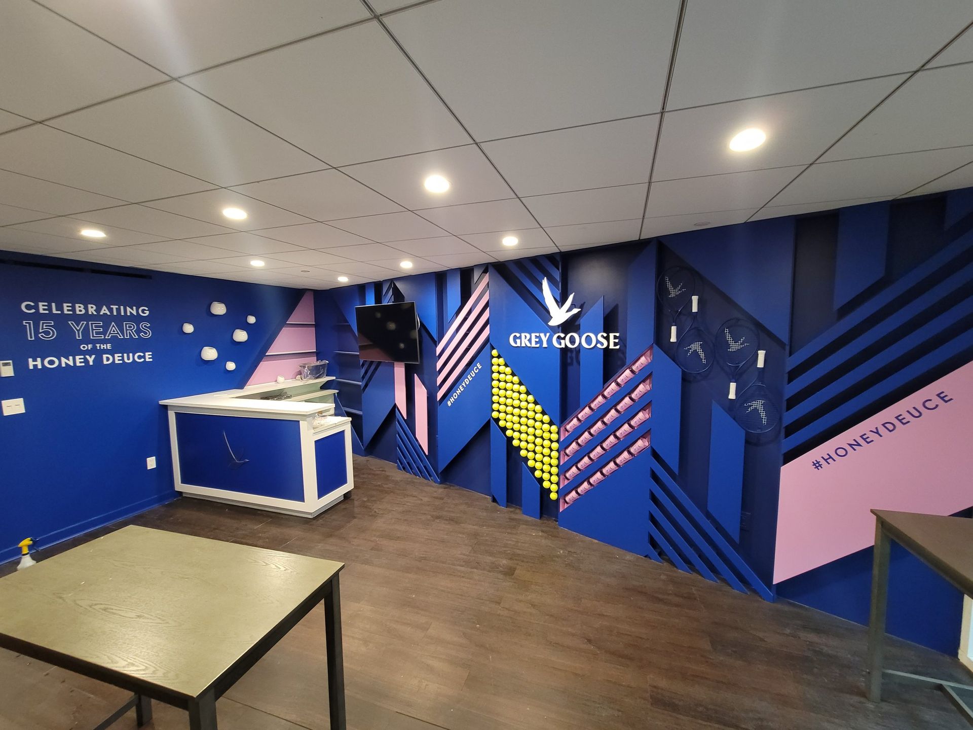 A room with a mural on the wall that says grey goose
